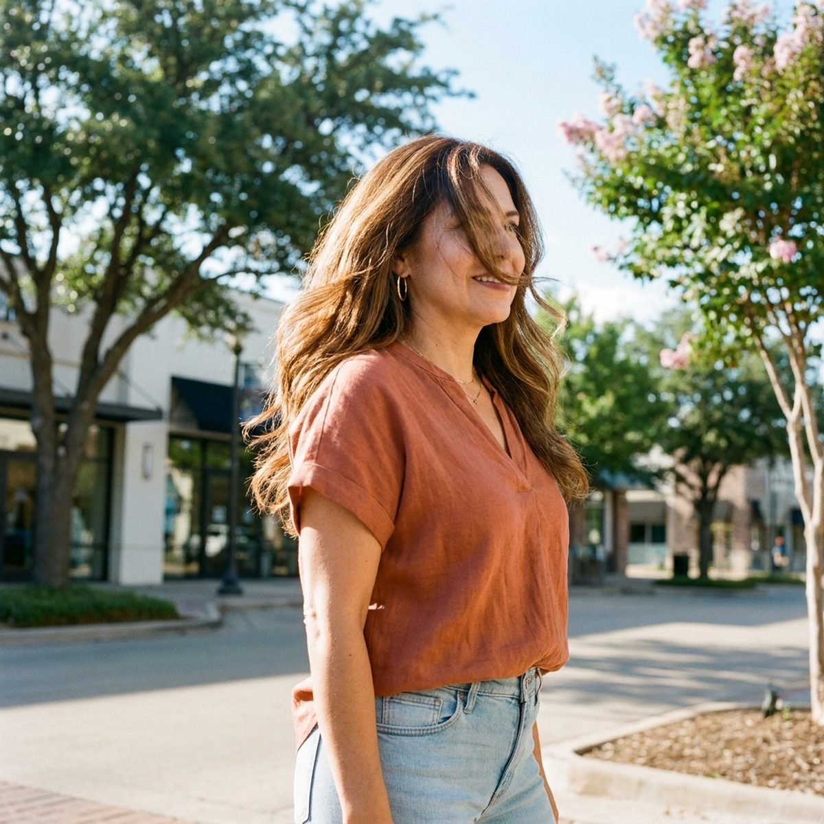 Confident Latina woman in her late 40s with dimensional caramel balayage, styled by Moxi Hair Studio in McKinney, TX