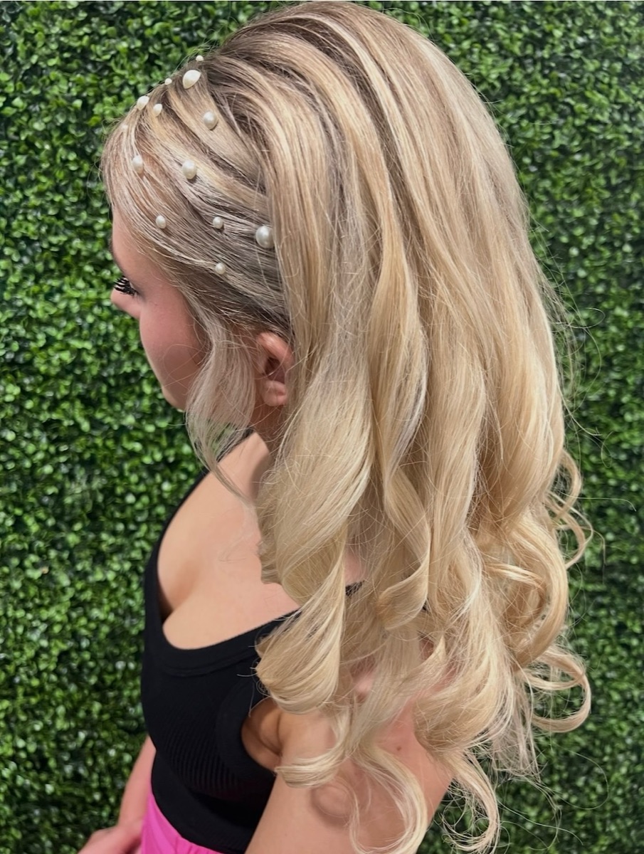 Blonde half-up half-down curled style with pearl accessories at Moxi Hair Studio