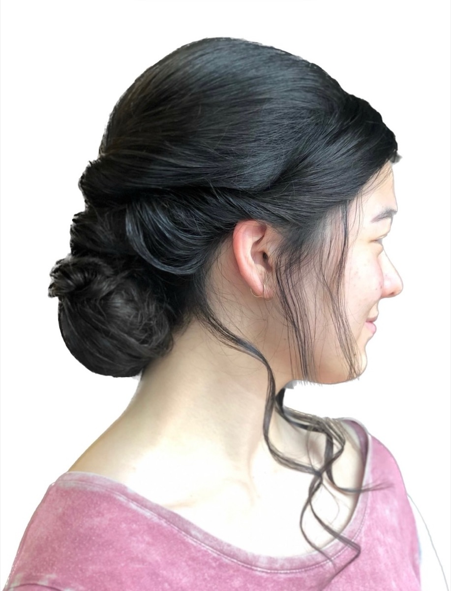 Elegant dark hair low bun updo at Moxi Hair Studio in McKinney, TX