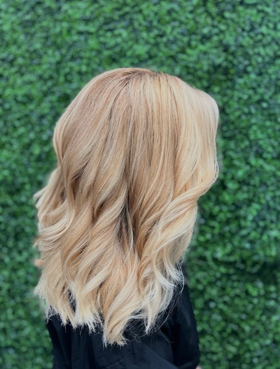 Warm blonde balayage on medium-length wavy hair at Moxi Hair Studio in McKinney, TX